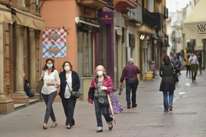 Personas con mascarillas pasean en Sevilla siguiendo las indicaciones de la OMS (Foto: Kiko Hurtado).
