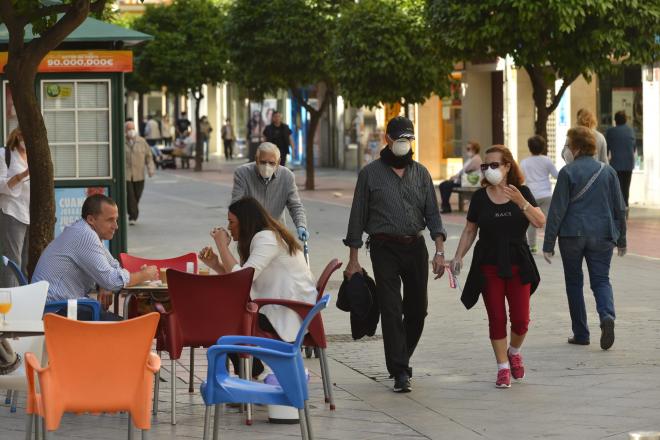 Personas en un bar y otras paseando con mascarillas en Sevilla (Foto: Kiko Hurtado).