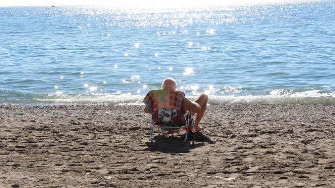 Un hombre toma el sol en una playa de Málaga (Foto: EFE).