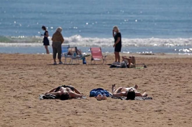 Bañistas en la playa dónde no es obligatoria la mascarilla (Foto: EFE)