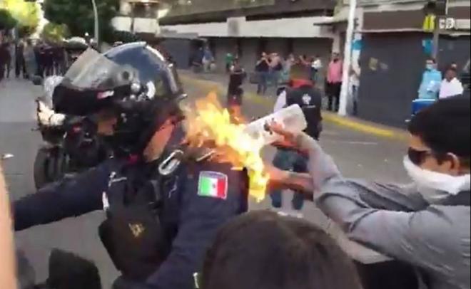 Manifestante prende fuego a un policía en México.