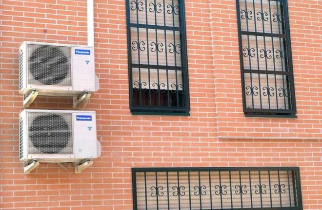 Dos máquinas de aire acondicionado en  una fachada (FOTO: EFE).
