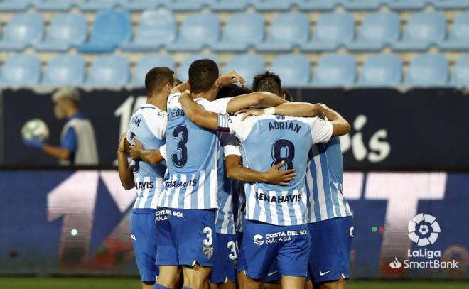 Varios jugadores del Málaga se abrazan tras el gol de Sadiku (Foto: LaLiga).