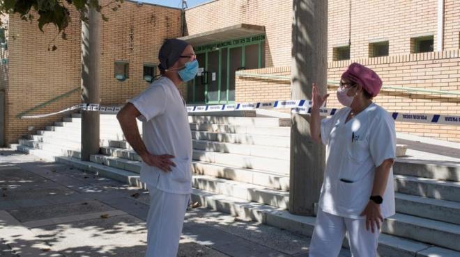 Dos sanitarios cumple con las medidas anti coronavirus en el polideportivo Cortes de Aragón de Fraga, Huesca (Foto: EFE).