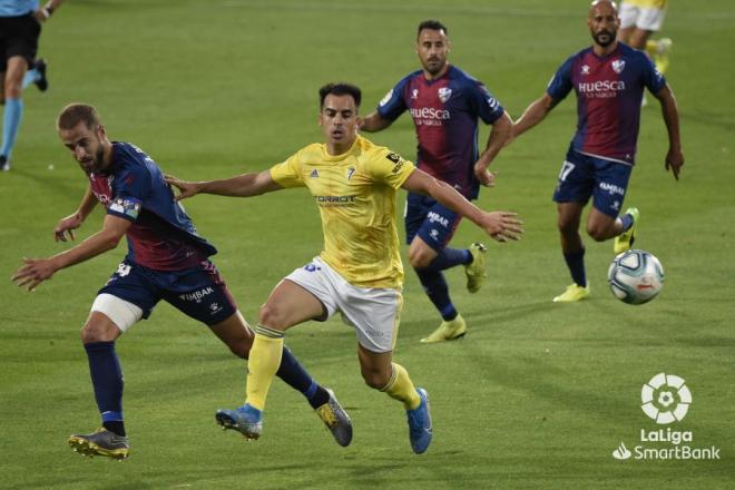 Jurado intenta marcharse de dos defensas, durante el Huesca-Cádiz (Foto: LaLiga).