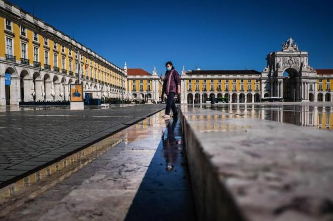 Una mujer con mascarilla camina por la plaza del Comercio de Lisboa (FOTO: EFE).