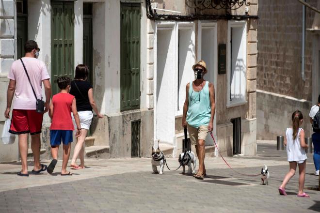 Varias personas, por las calles de Mahón (Menorca) con mascarillas (Foto: EFE/ David Arquimbau)
