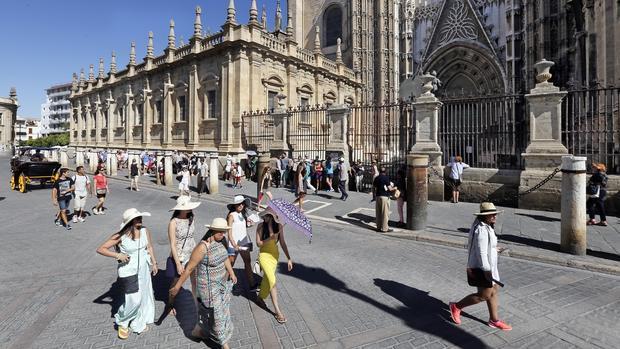 Sevillanos paseando por el entorno de la Catedral de Sevilla.