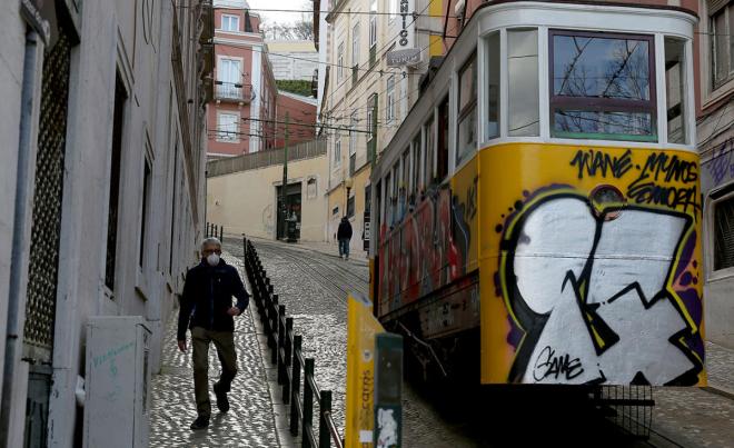Un hombre pasea por Lisboa con mascarilla ante la epidemia del coronavirus.