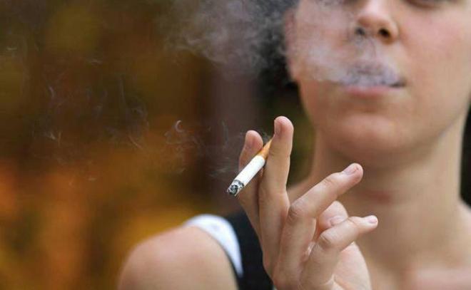 Una mujer, fumando en la calle: cuidado con hacer eso en Qatar (Foto: EFE).