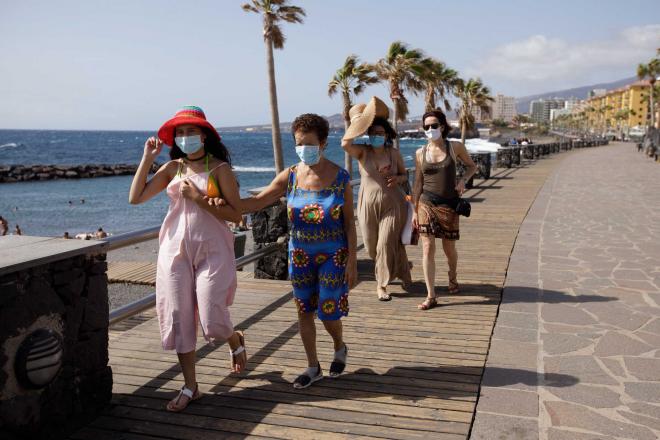 Cuatro mujeres caminan por un paseo marítimo durante la pandemia de coronavirus en pleno agosto.