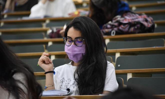 Una estudiante realiza un examen con mascarilla.