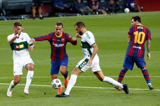 Griezmann conduce el balón ante la presión de dos jugadores del Elche (FOTO: EFE).