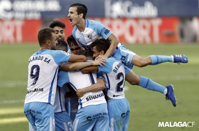 Matos sobrevuela varios compañeros celebrando un gol (Foto: Málaga CF).