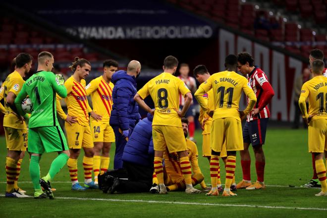 Gearard Piqué es atendido por los servicios médicos durante el Atlético-Barcelona (FOTO: EFE).