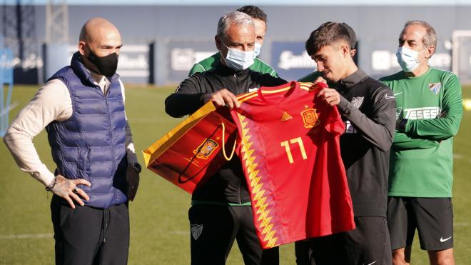 Manolo y Pellicer, haciendo entrega a Larrubia de una camiseta (Foto: Málaga CF).
