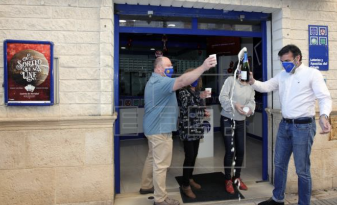 Una administración de lotería de Gandia celebra haber vendido números premiados. EFE/ Natxo Fran