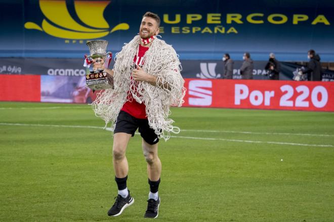 Unai Simón, con el trofeo en la mano, se lleva la red de la portería de La Cartuja tras ganar la Supercopa (Foto: Athletic Club).