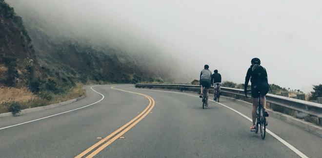 Varios ciclistas por una carretera.