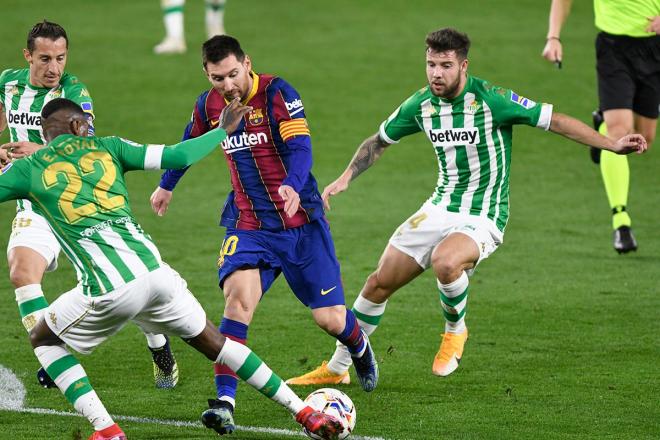 Leo Messi se marcha de dos rivales en un partido ante el Real Betis.