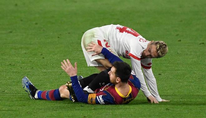 El Papu Gómez, sobre Leo Messi tras una acción del Sevilla-Barça (Foto: Kiko Hurtado).