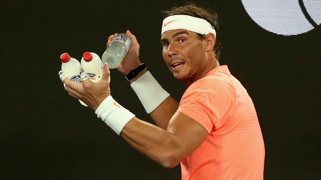 Rafa Nadal, con varias botellas en sus manos durante un partido del Open de Australia.