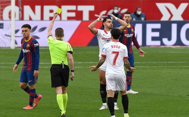 Hernández Hernández señala cartulina amarilla a un jugador del Sevilla (Foto: Kiko Hurtado).