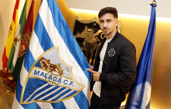 Ale Benítez, posando con una bandera del Málaga tras renovar (Foto: Málaga CF).