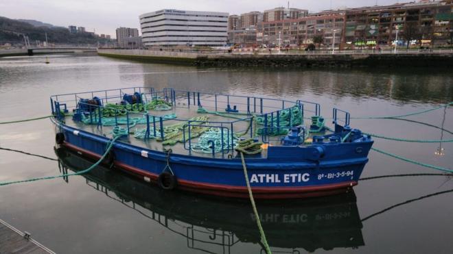 La gabarra Athletic reposa mansamente en aguas de la Ría de Bilbao.