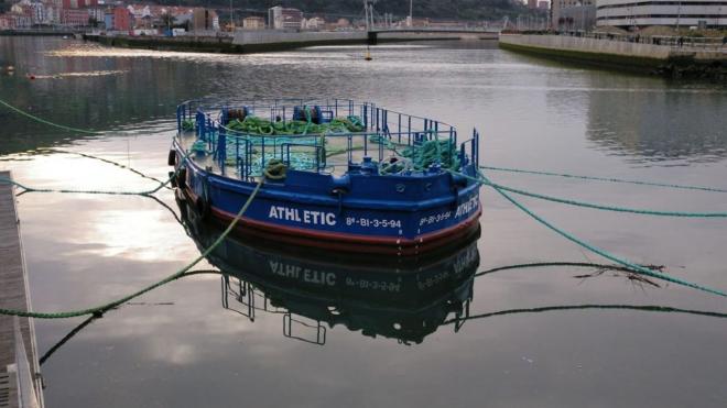 La gabarra Athletic reposa mansamente en aguas de la Ría de Bilbao.