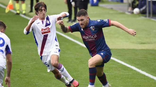 Javi Galán conduce la pelota ante la presión de Bryan Gil en un Huesca-SD Eibar de la pasada temporada.