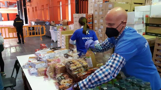Un voluntario organiza la comida antes de ser entregada en Mestalla.