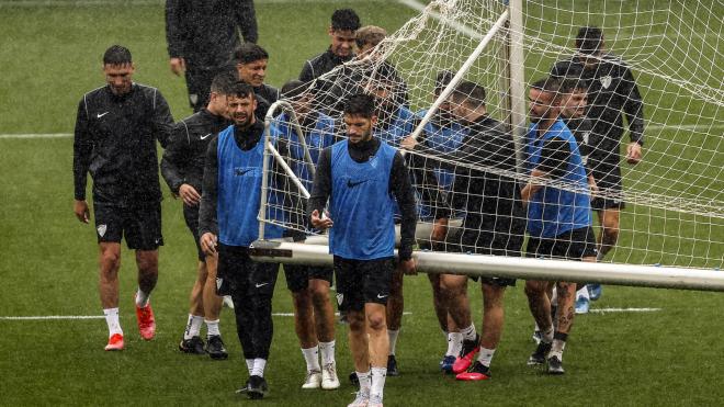 Varios jugadores trasladan una portería bajo la lluvia (Foto: Málaga Cf).