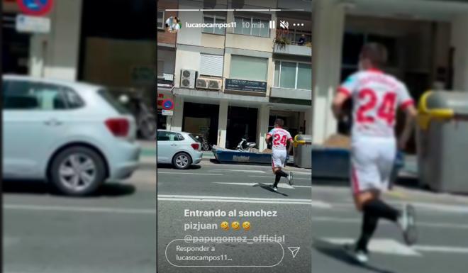 El Papu Gómez, vestido de futbolista cruzando la calle.