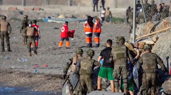 Militares españoles acompañan a menores tras cruzar a Ceuta desde Marruecos (Foto: EFE).