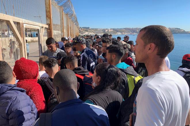 Varios migrantes esperan a cruzar en la frontera entre Ceuta y Marruecos (Foto: EFE).