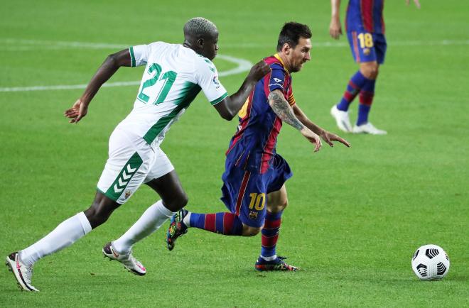 Mfulu persiguiendo a Messi en un partido con el Elche (Foto: Cordon Press).