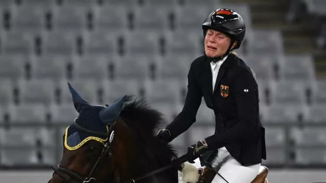 La alemana Annika Schleu llora sobre su caballo.