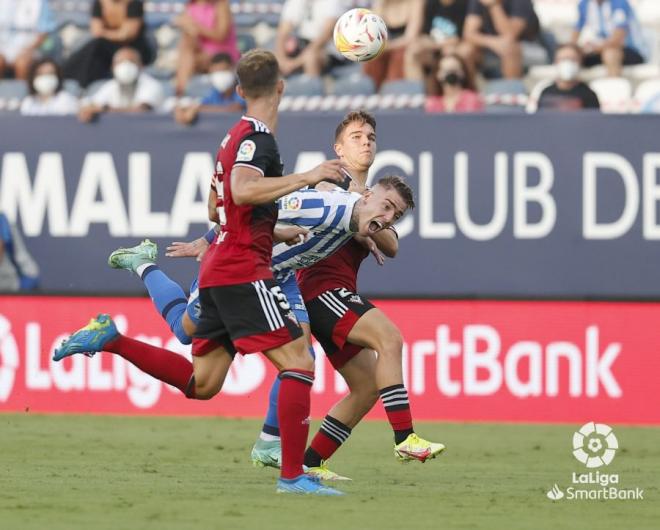 Brandon, entre dos rivales, en el Málaga-Mirandés (Foto: LaLiga).