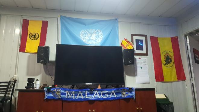 Una bufanda del Málaga viste la sala de la televisión.