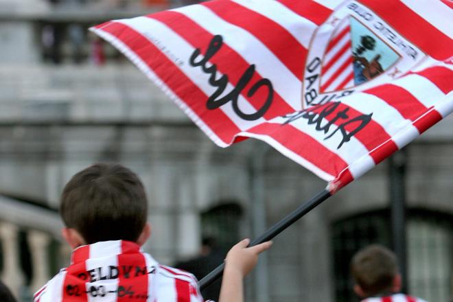 Un niño en Bilbao con la camiseta y la bandera del Athletic Club.