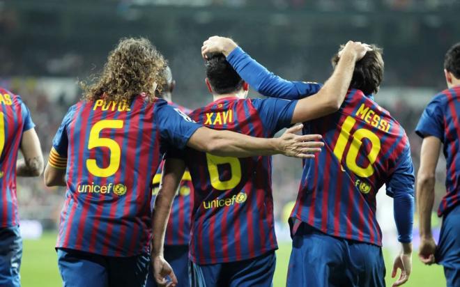 Carles Puyol, Xavi Hernández y Leo Messi celebran un gol con el Barcelona.