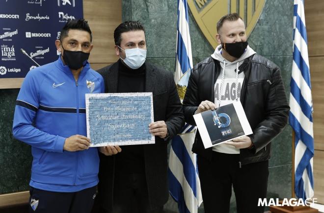 Basti posa con el cartel que representa la primera piedra de su Peña Malaguista (Foto: Málaga CF)