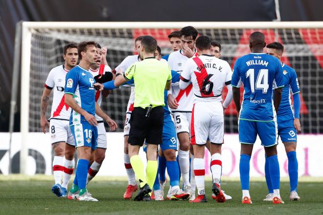 Los jugadores del Betis protestan a Muñiz Ruiz en el partido de Vallecas (Foto: Cordon Press).