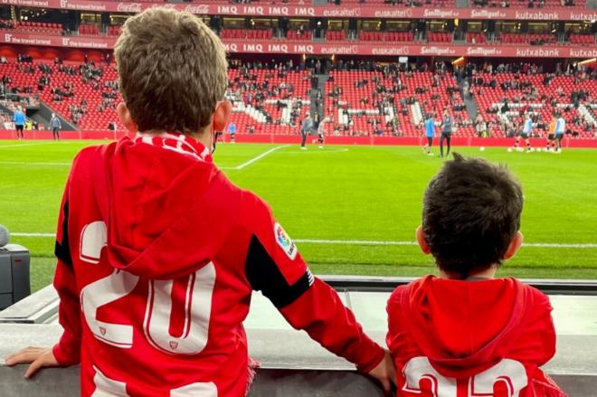 Dos niños viendo calentar al Athletic Club en San Mamés desde la banda.