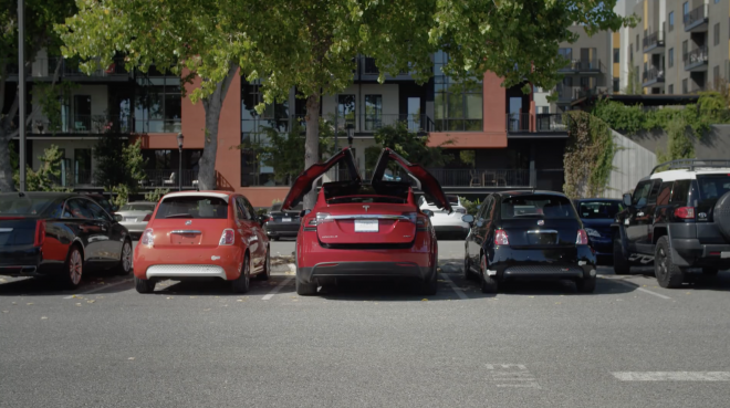 El Tesla Model X, en el centro de la imagen cerrando sus puertas.