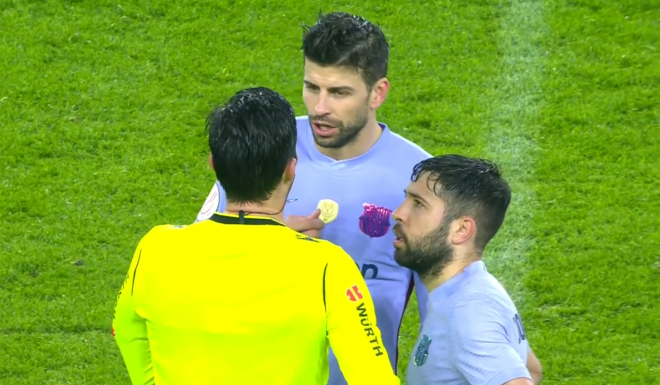 Piqué y Alba protestan al árbitro.