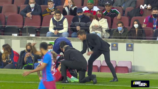 Simeone levanta a Wass del césped del Camp Nou.