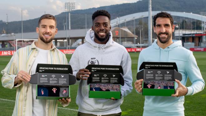 Iñigo Martínez, Iñaki Williams y Raúl García posan con el pack de los 3 calcetines solidarios en Lezama.