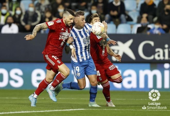 Brandon, entre dos rivales en el Málaga-Cartagena (Foto: LaLiga).